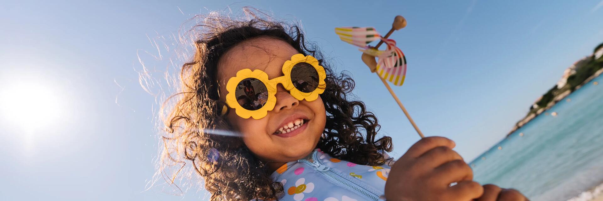 Femme qui porte un bandana et une paire de lunettes de soleil polarisé, elle est en randonnée dans les montagnes