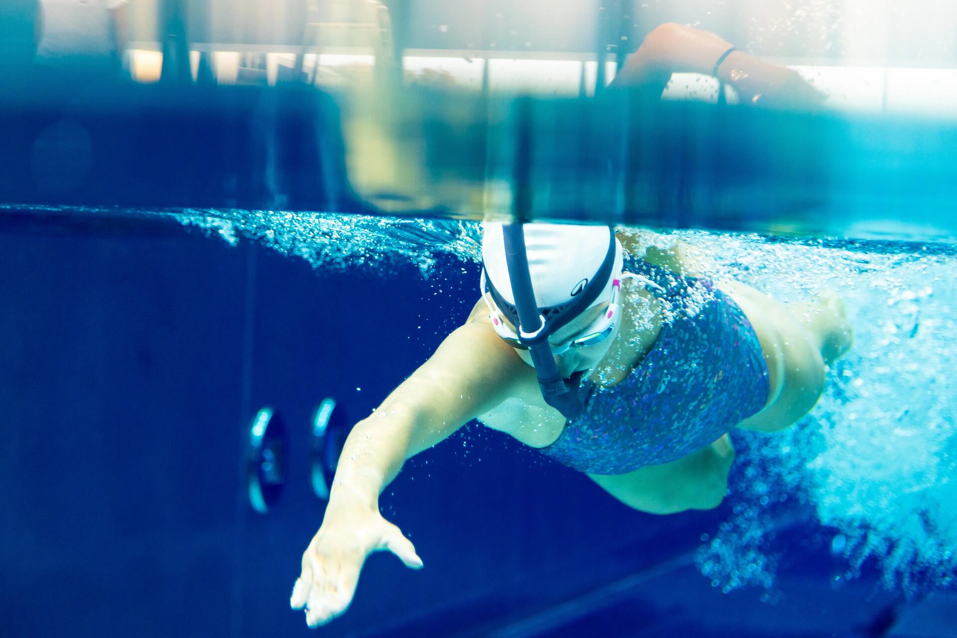 femme nageant le crawl en piscine pendant l'hiver