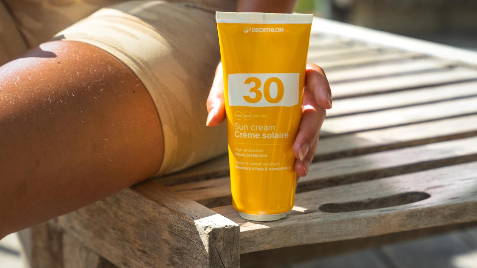 Flacon de crème solaire posé sur un banc