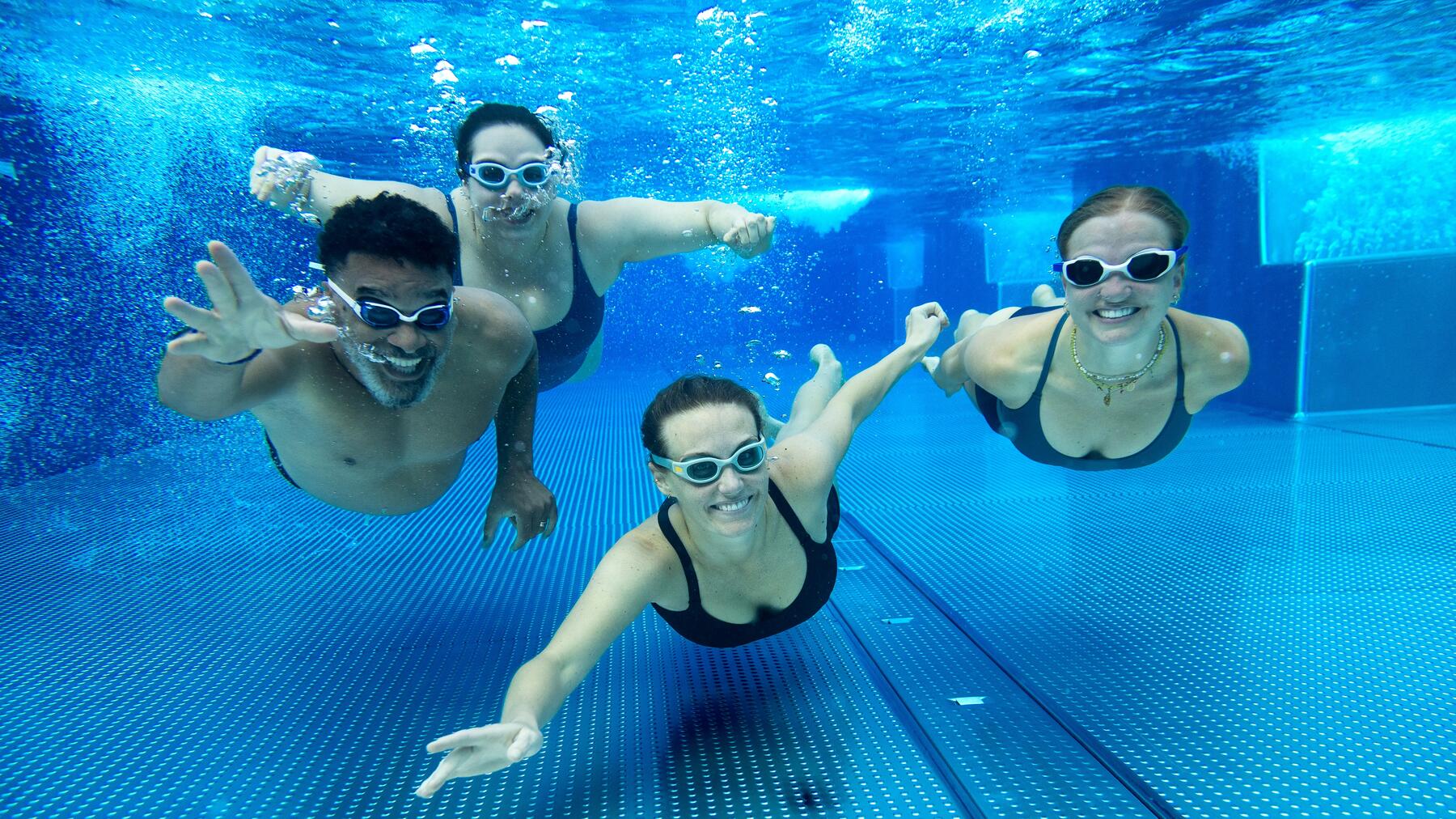 Eine Gruppe von Freunden schwimmt im Pool gegen Cellulite