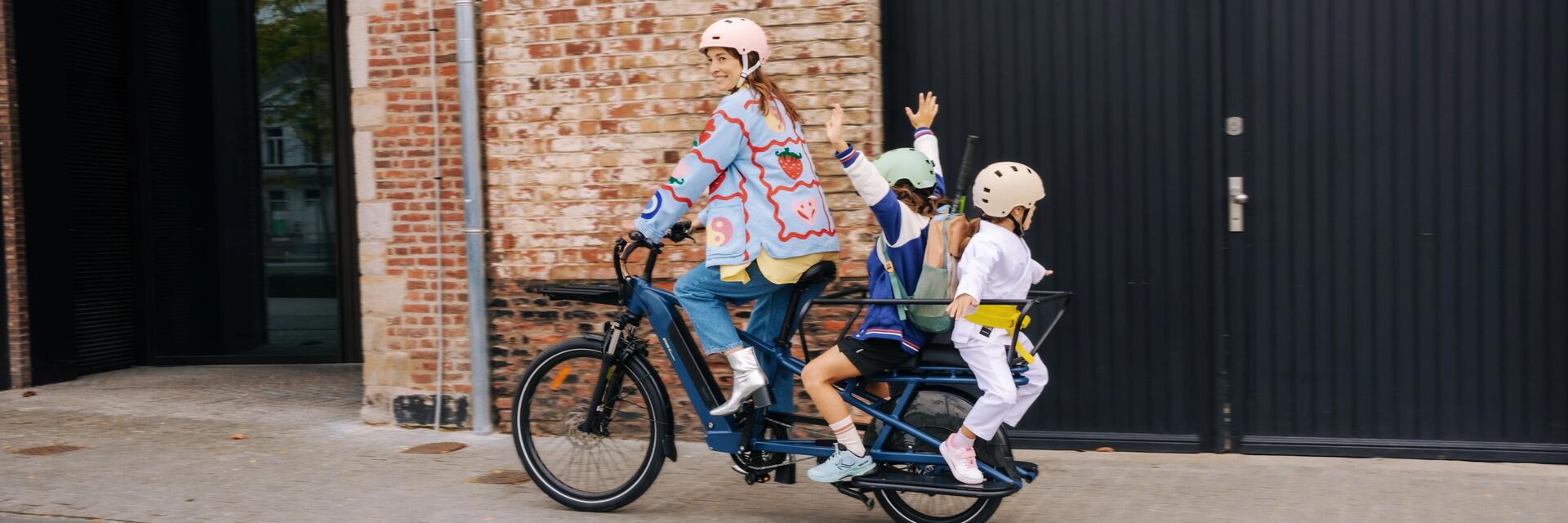 Une femme et ses enfants avec son vélo cargo Decathlon
