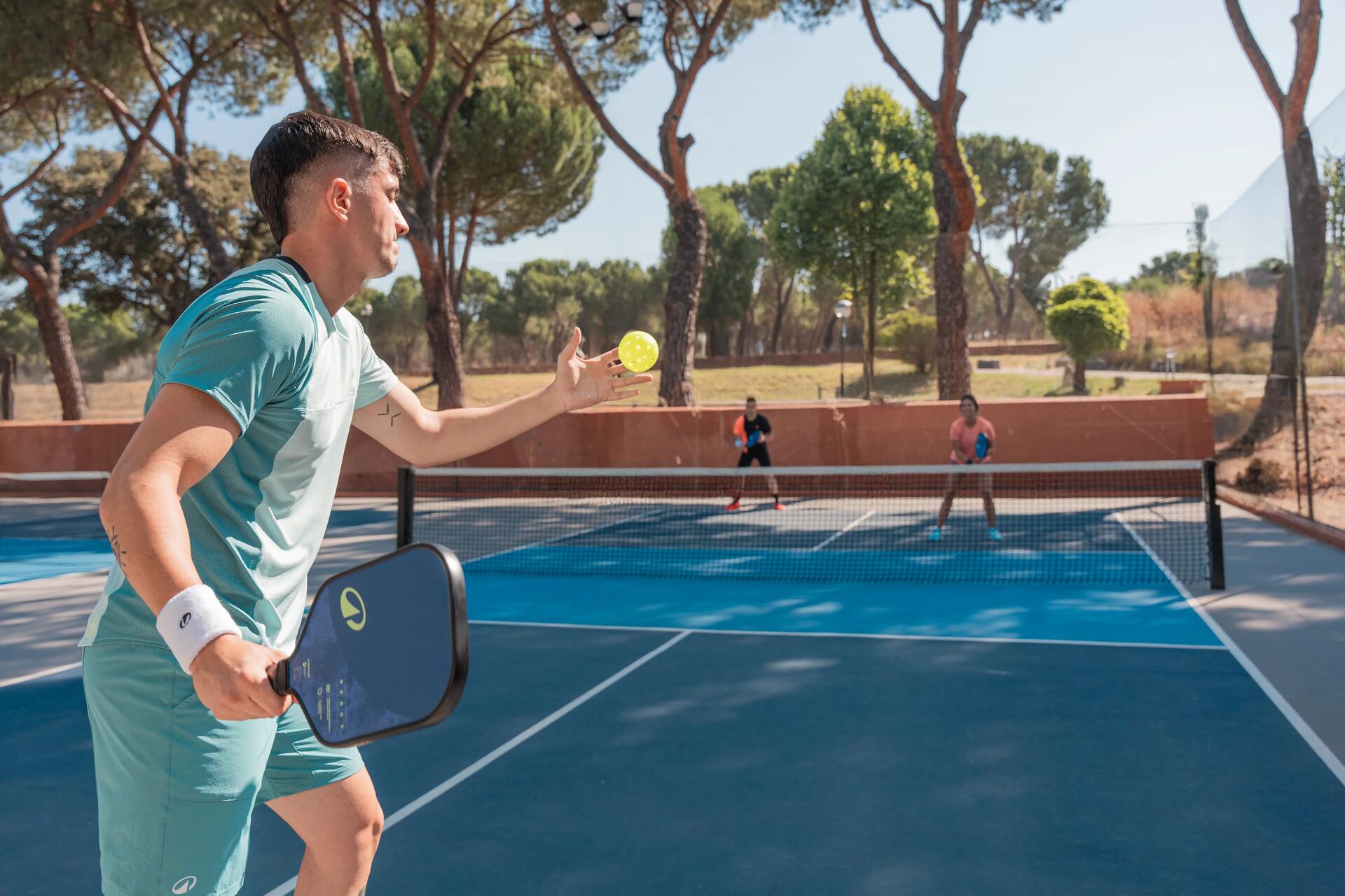 Troje ludzi grających w pickleball