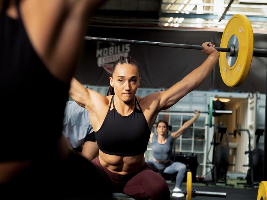 two people squatting back to back