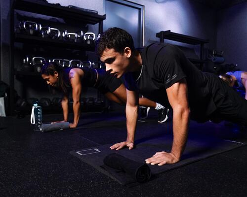 femme qui réalise des tractions à la barre fixe avec un gilet lesté