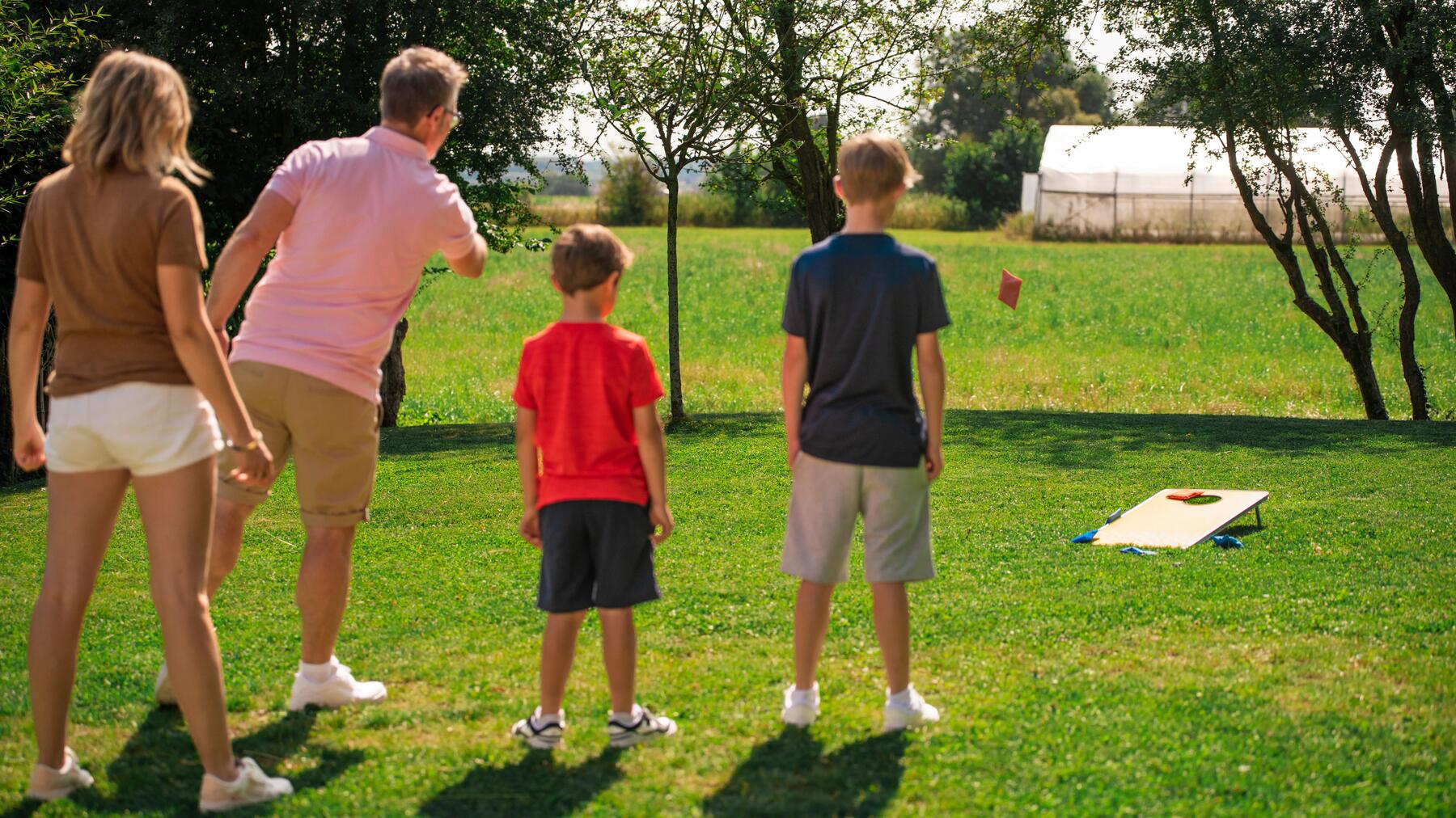 Een gezin speelt cornhole in hun tuin