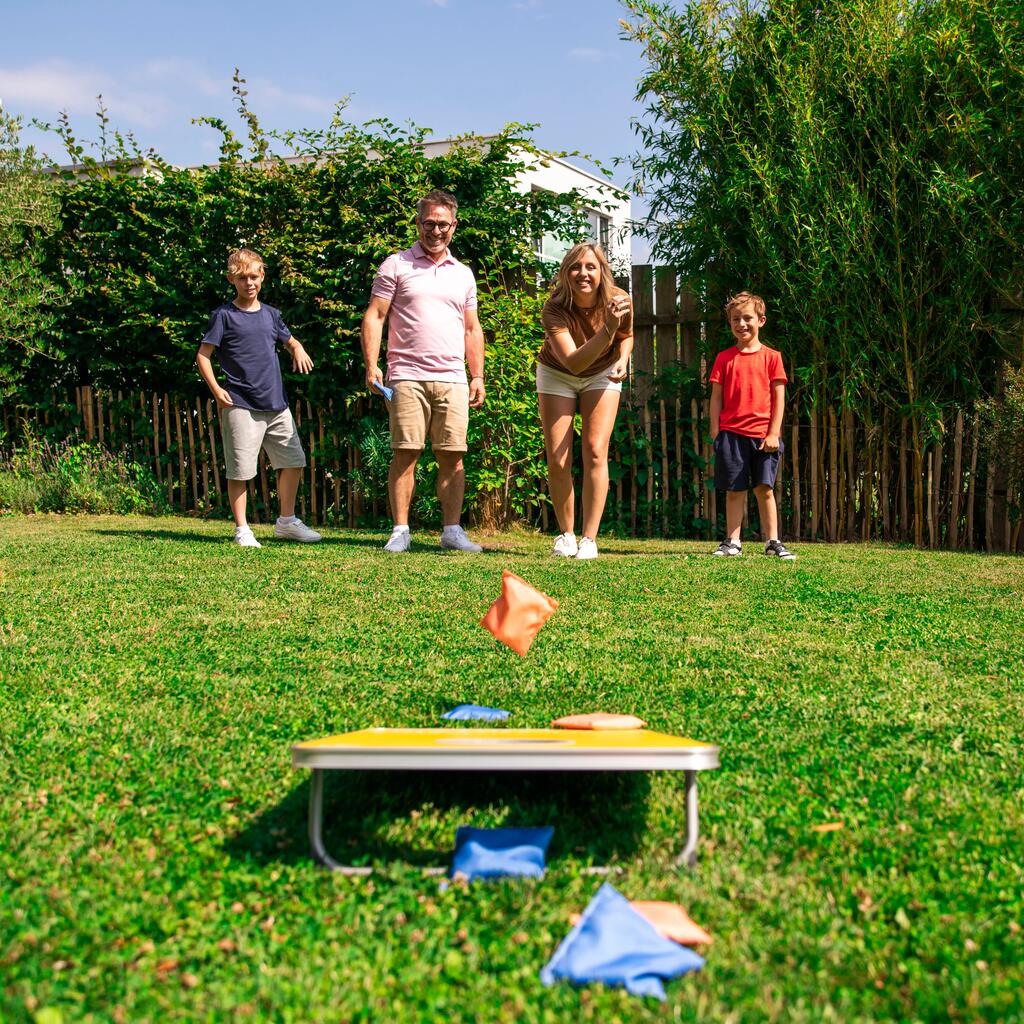 Družina igra cornhole igro na zelenici