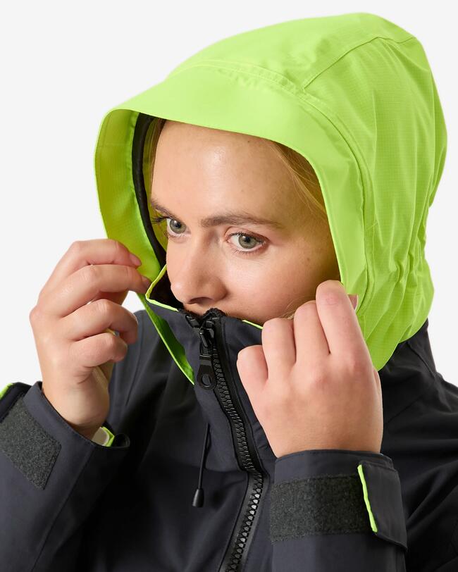 detailní záběr na ženu v vestě s neonově zbarvenou kapucí 