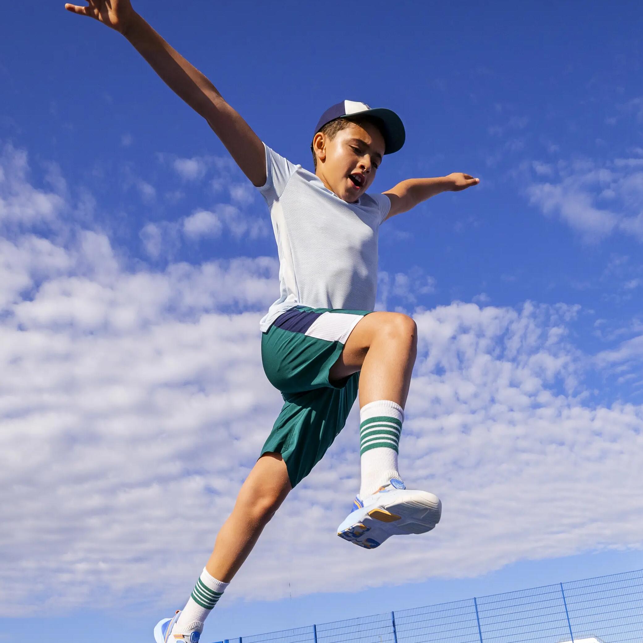 Junge in sportbekleidung springt in die luft im hintergrund der blaue sommerhimmel