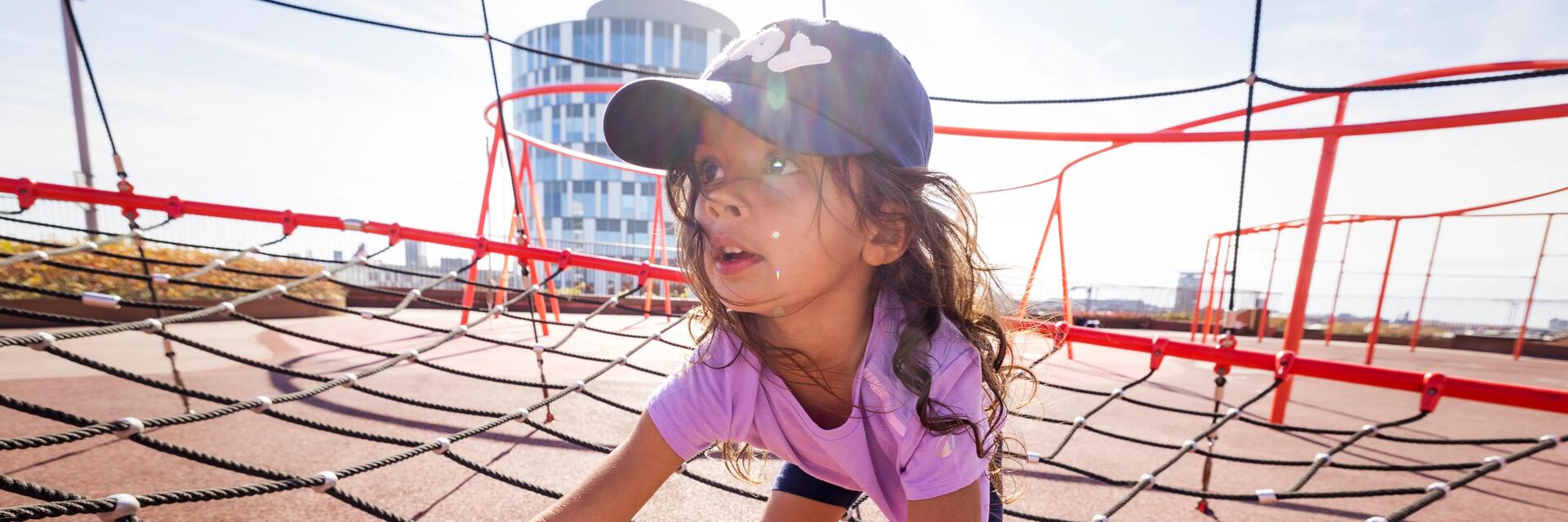 Ein Kind klettert auf dem Spielplatz mit einem UV-Shirt