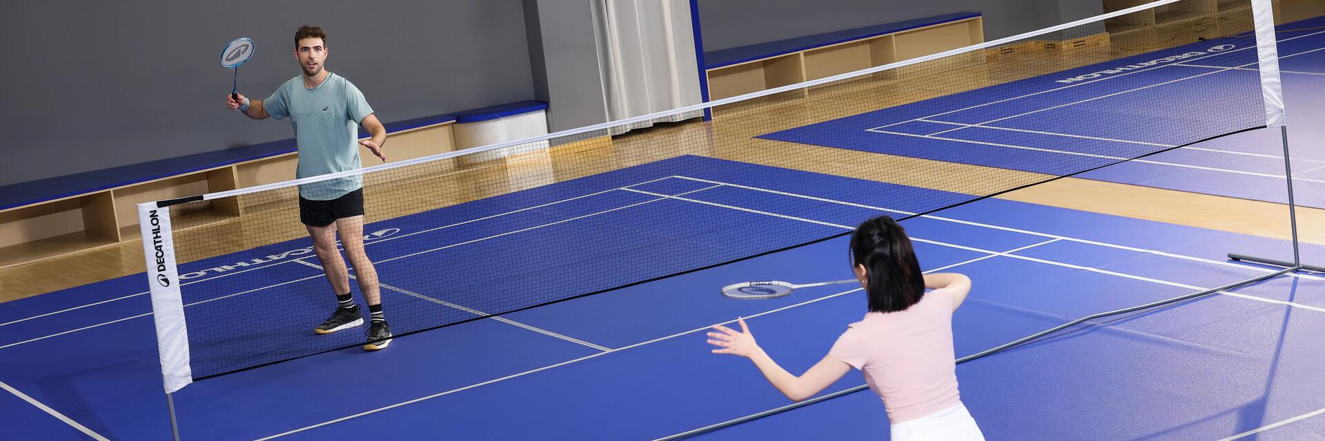 Kobieta i mężczyzna grajacy w badmintona na sali sportowej