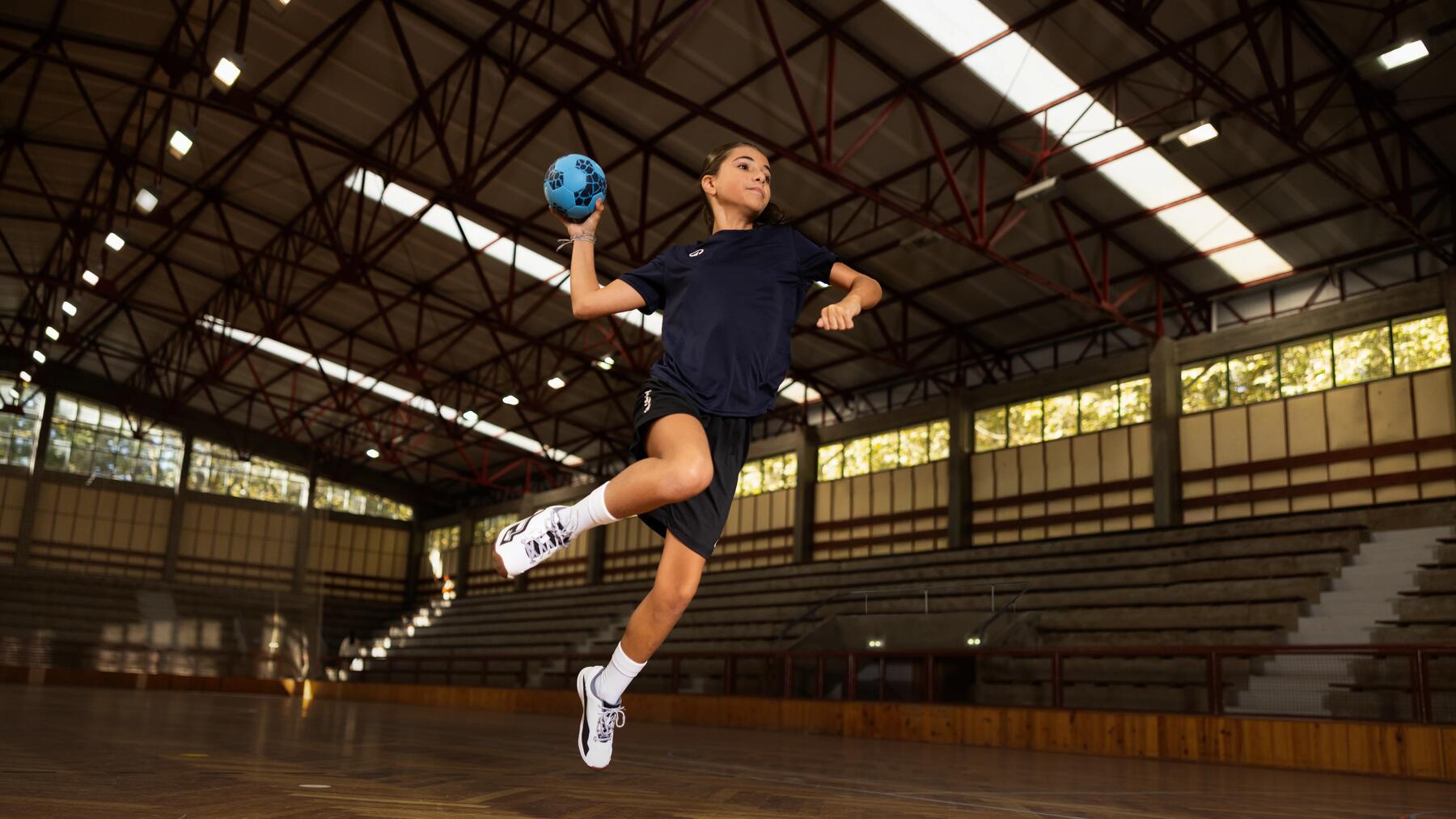 Ein Mädchen wirft einen Handball in der Halle