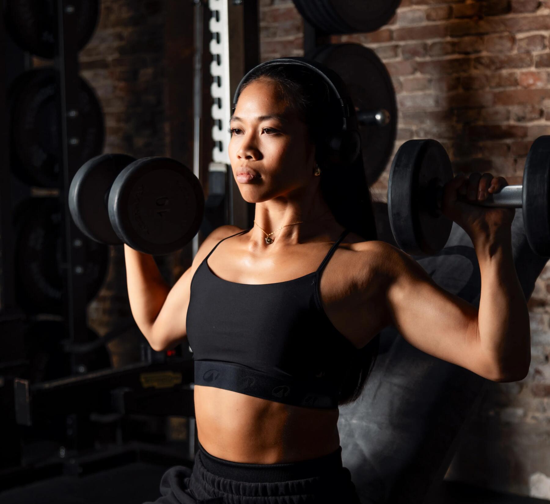Eine Frau macht Hanteltraining mit dem richtigen Sport-BH