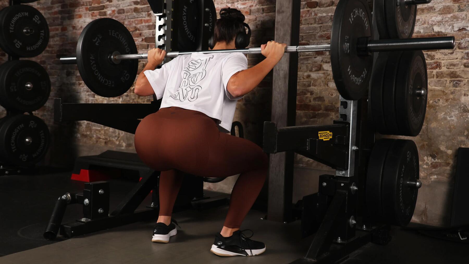Een vrouw doet squats en draagt Energy+-fitnessschoenen