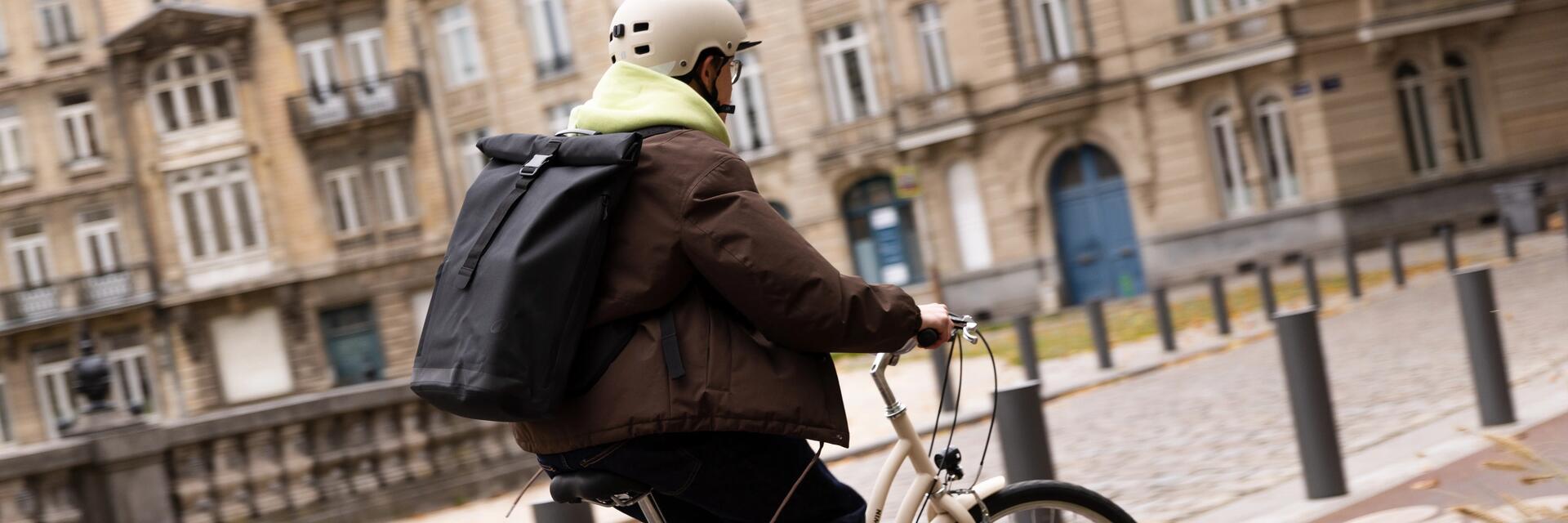 Mężczyzna w kasku rowerowym jadący na rowerze miejskim zastanawiający się czy kask roweorwy jest obowiązkowy