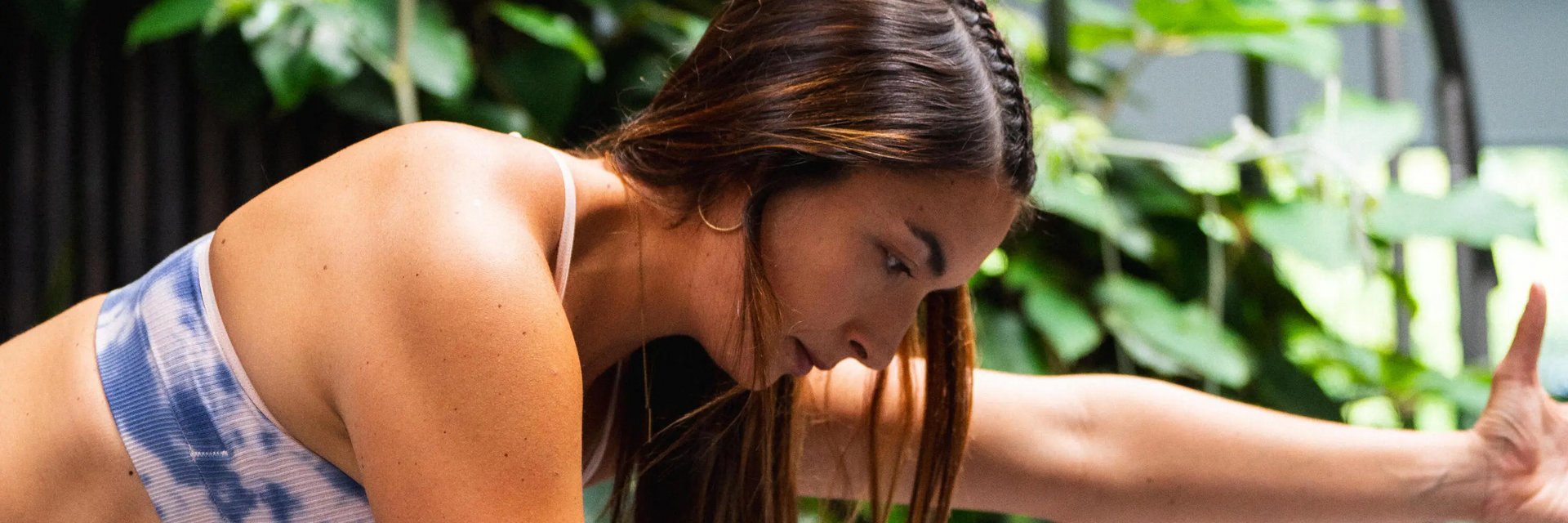 Eine Frau macht eine entspannende Yogaübung auf einer Matte im hellen Raum gegen Stress.