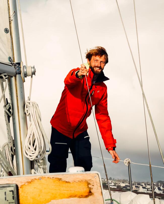 marin en tenue veste de quart rouge et salopette noire de quart