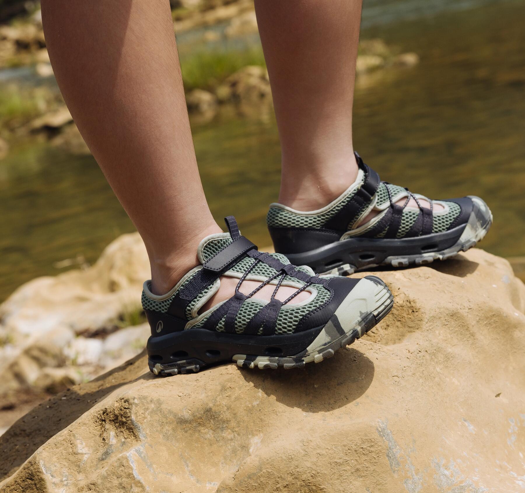 Eine Person geht mit Sandalen durch einen Fluss