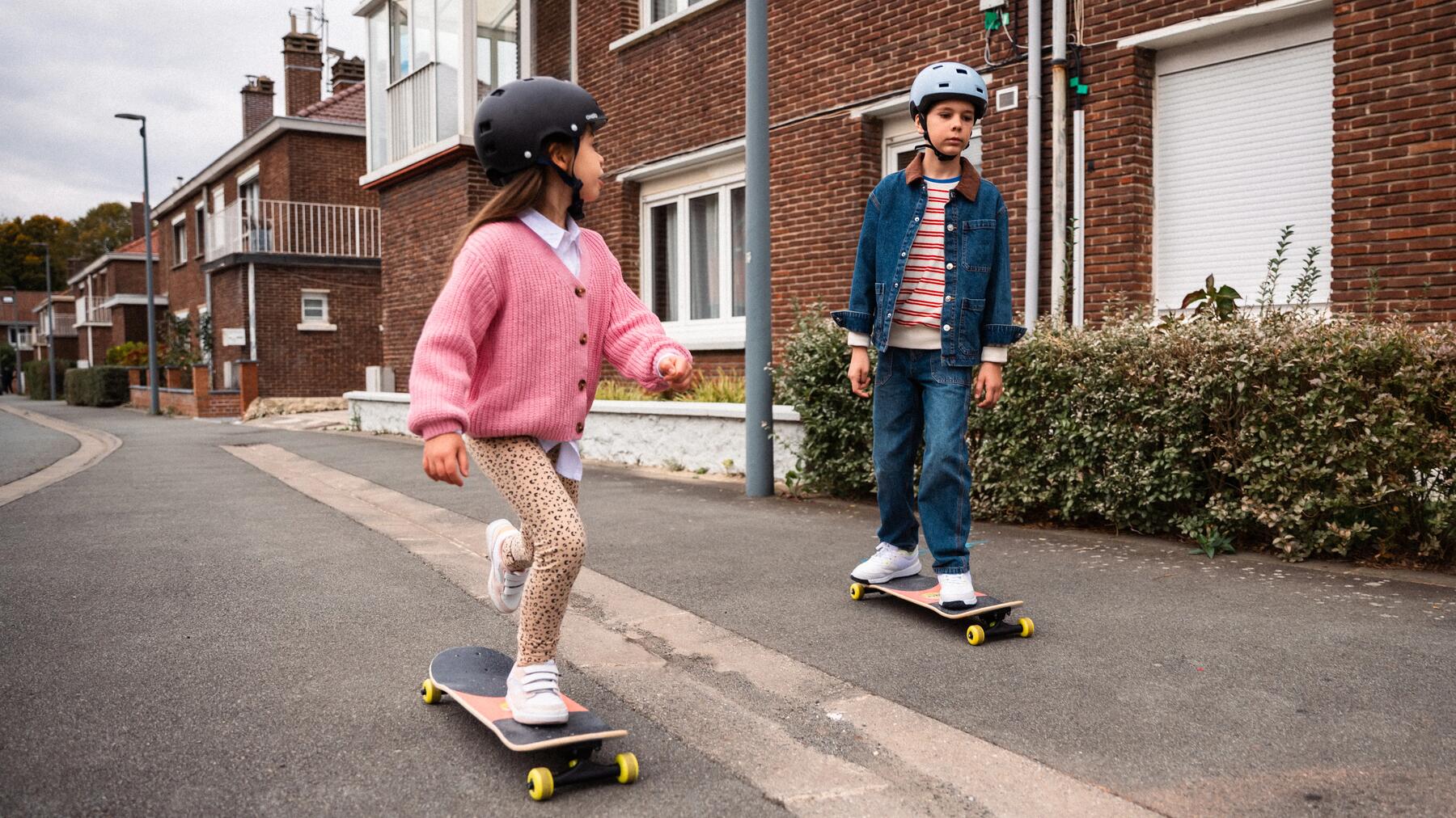 Kinder lernen Skateboarden auf einer ruhigen Straße