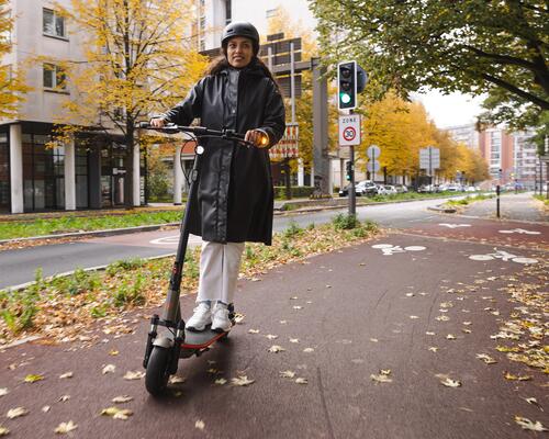 duas pessoas a andar de trotinete na cidade