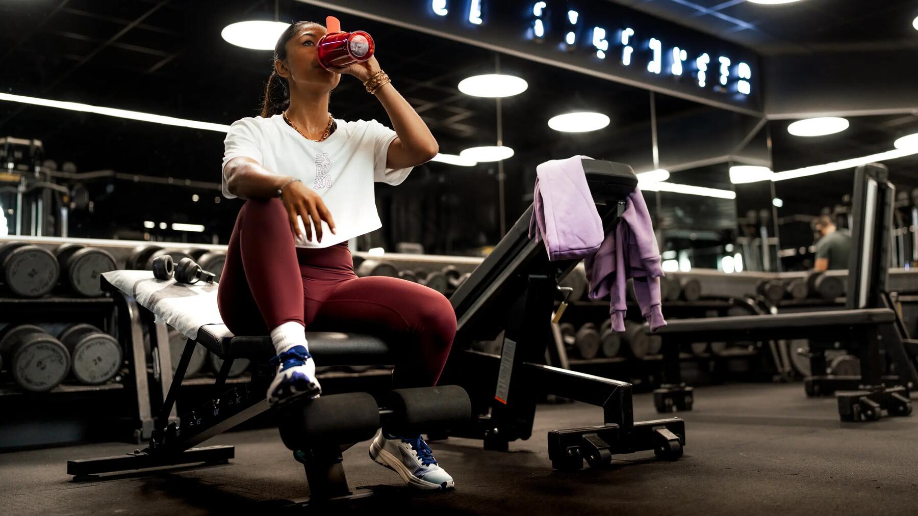 Vrouw in de gym op een bench met fitness schoenen aan