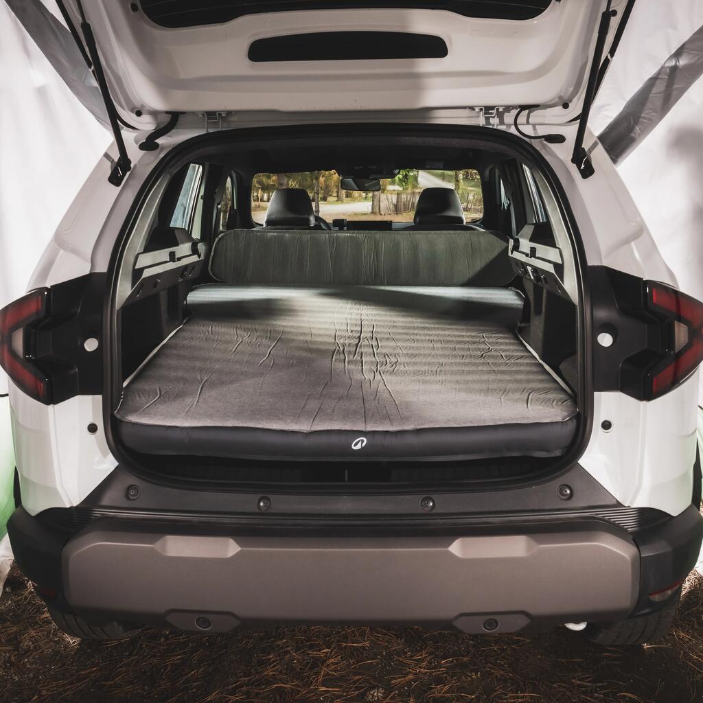 Pogled na unutrašnjost prtljažnika belog automobila u kojem je postavljen sivi Quechua Ultim Comfort dušek na naduvavanje