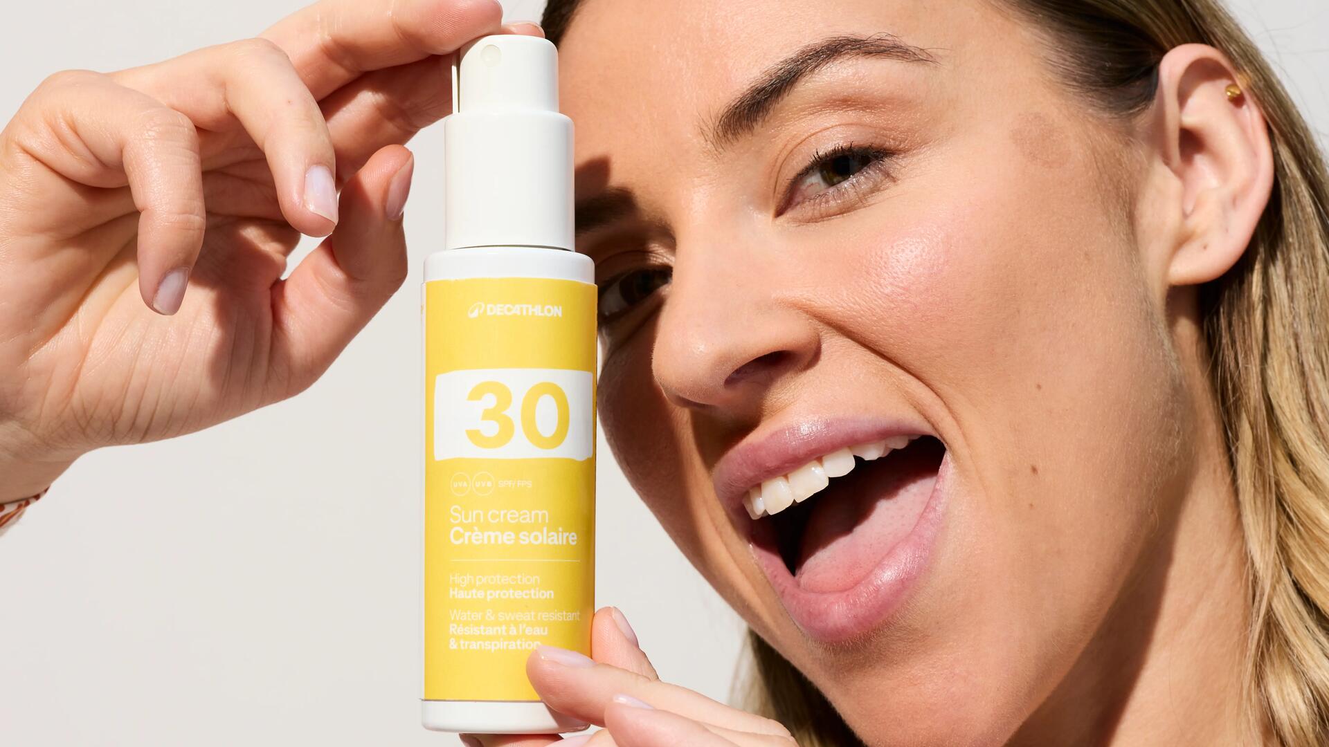 Femme tenant un flacon de crème solaire