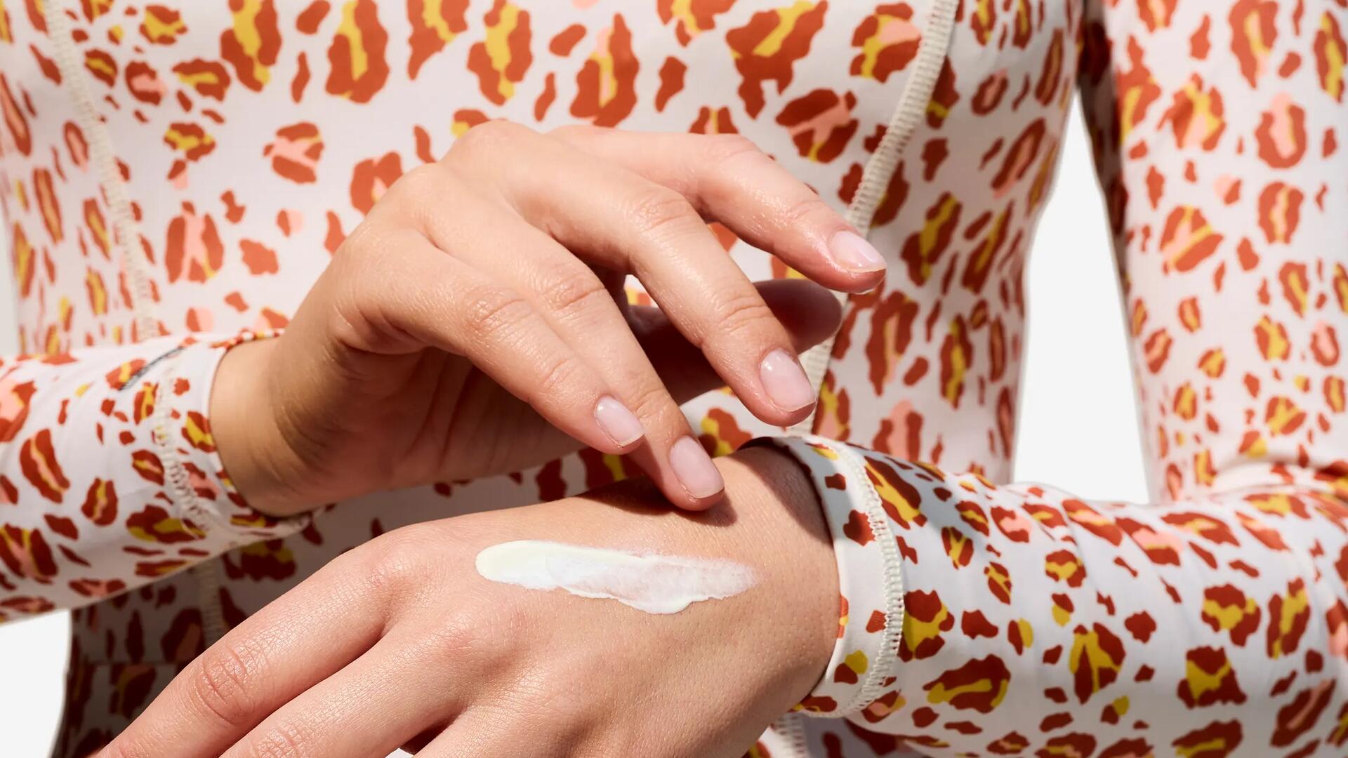 Femme appliquant de la crème solaire sur sa main