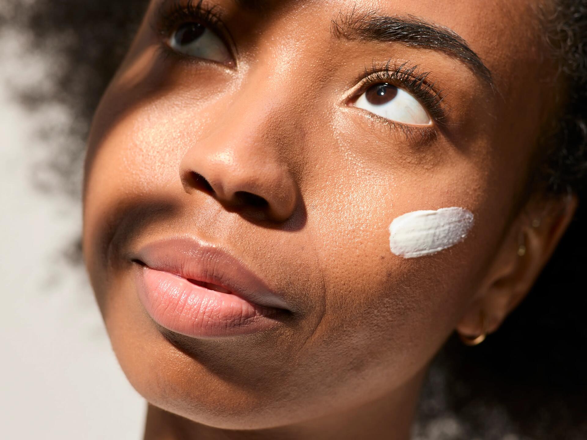 femme avec de la crème solaire sur le visage