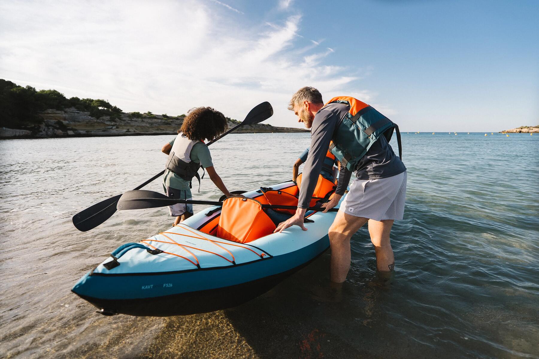 Ein paar Personen bringen das Kajak ins Wasser