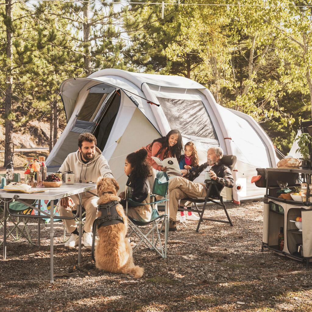Porodica sa psom uživa u kampovanju na otvorenom ispred velikog Quechua šatora na naduvavanje.