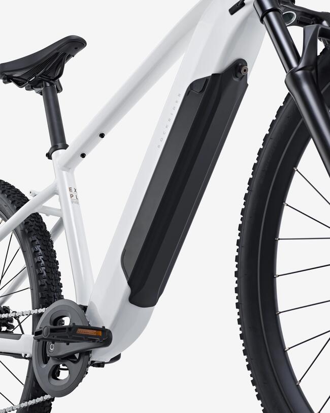 Seitenansicht des Rahmens eines weißen E-Mountainbikes mit integriertem schwarzem Akku im Unterrohr. Zu sehen sind zudem der Sattel, die Pedale sowie Teile der Federgabel und der profilierten schwarzen Reifen vor weißem Hintergrund.