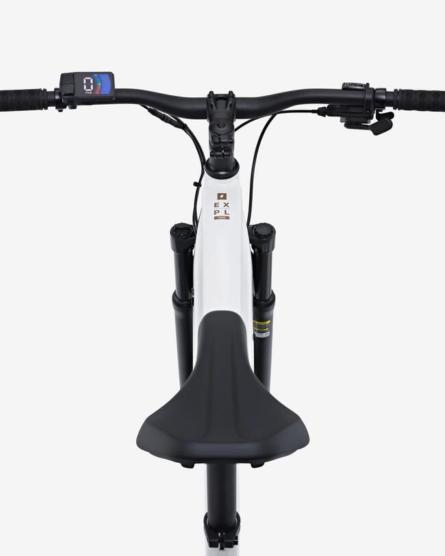 Vogelperspektive auf den Lenker und das Oberrohr eines weißen E-Mountainbikes. Zu sehen sind das digitale Display auf der linken Seite, die schwarzen Griffe, der Sattel im Vordergrund sowie der „EXPL 100“-Schriftzug auf dem Rahmen.