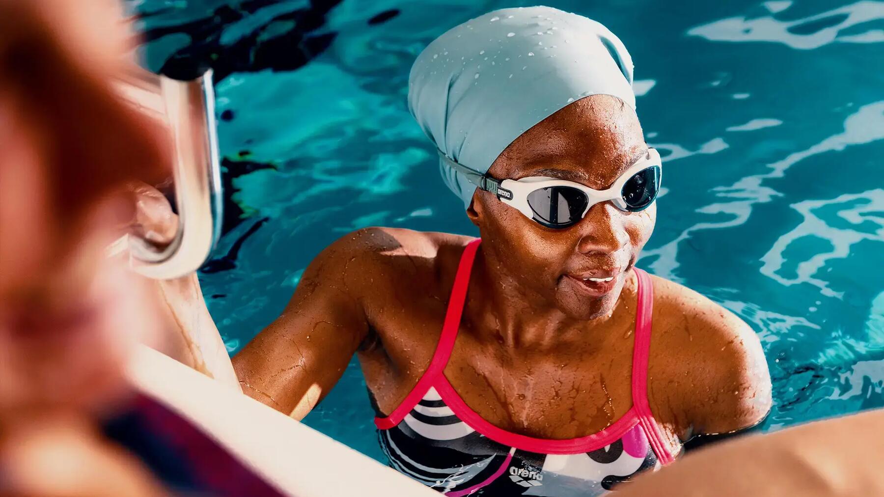 Eine Frau schwimmt am Beckenrand und hat richtig geatmet