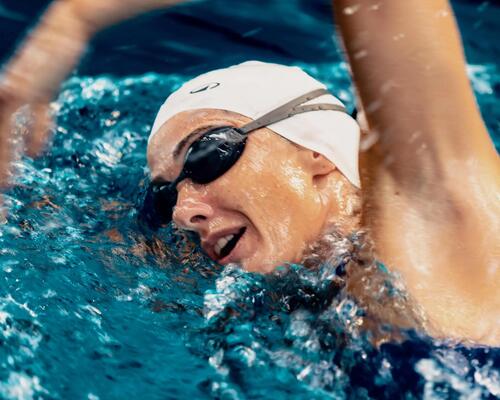 Eine Frau schwimmt und atmet dabei durch den Mund