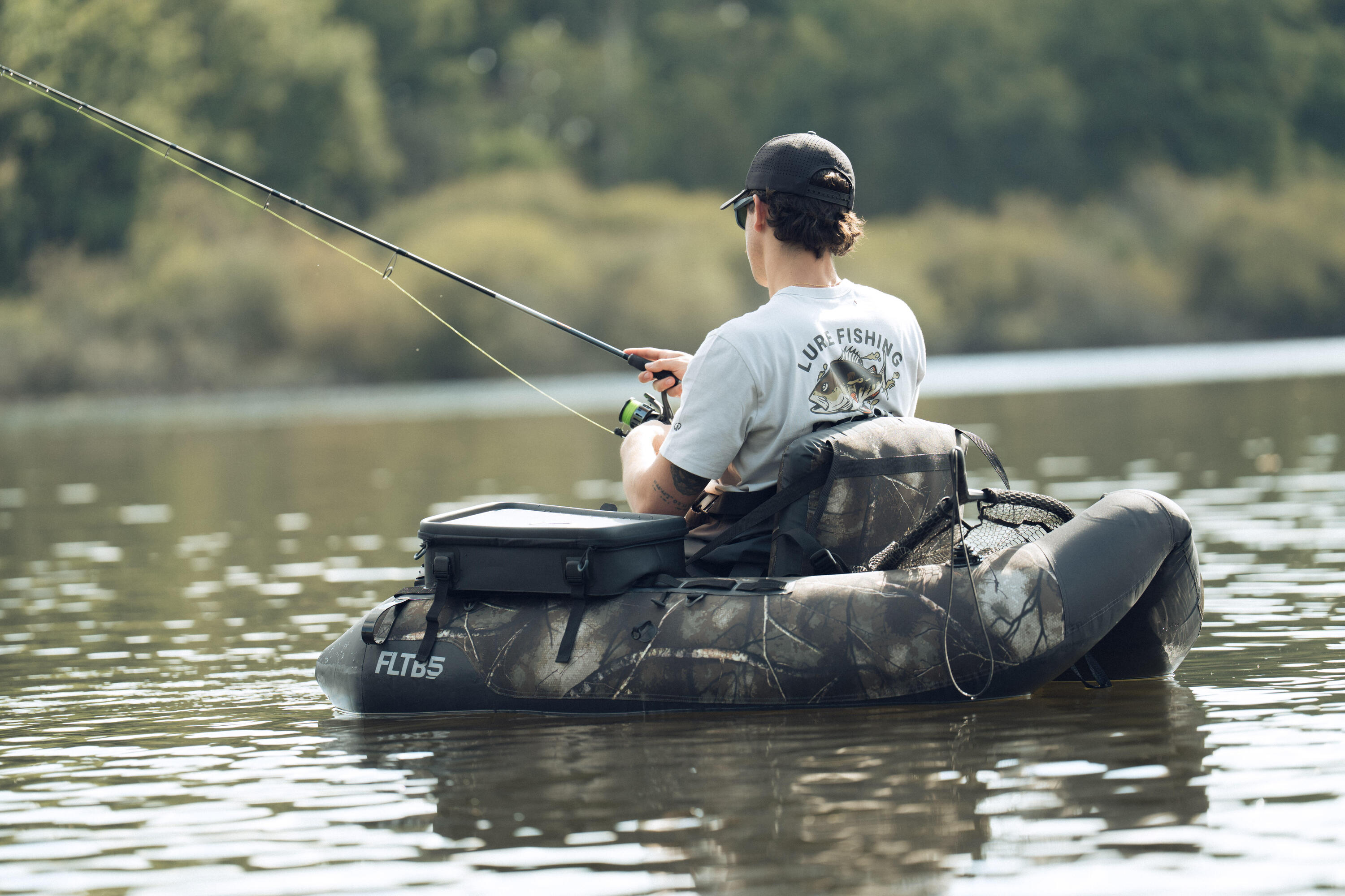 Ein ANgler sitzt im Bellyboot auf dem Wasser und angelt
