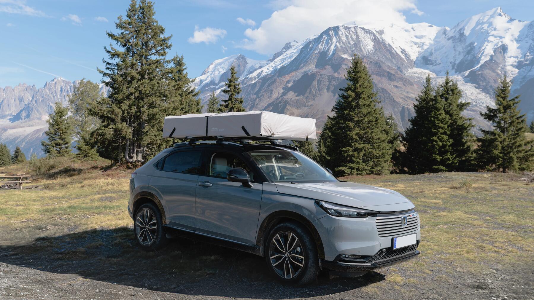 Camping mit dem Auto und Dachzelt vor den Bergen