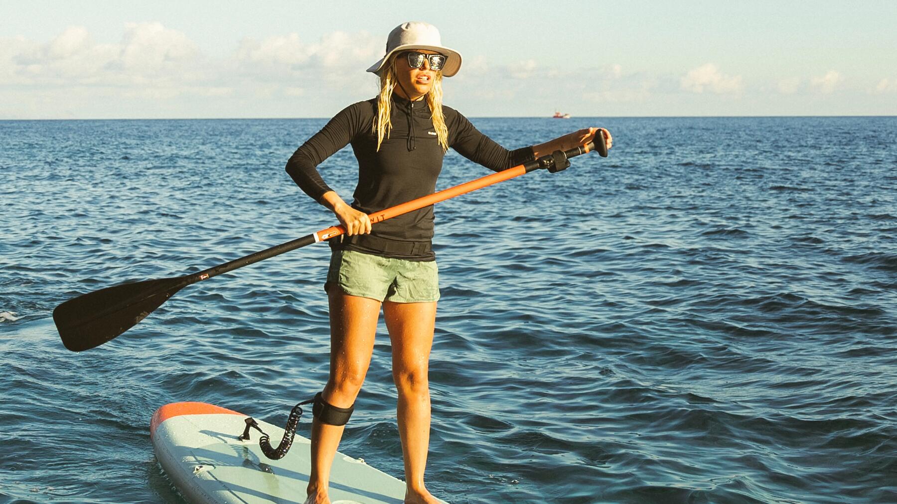 Eine Frau fährt SUP auf dem Meer