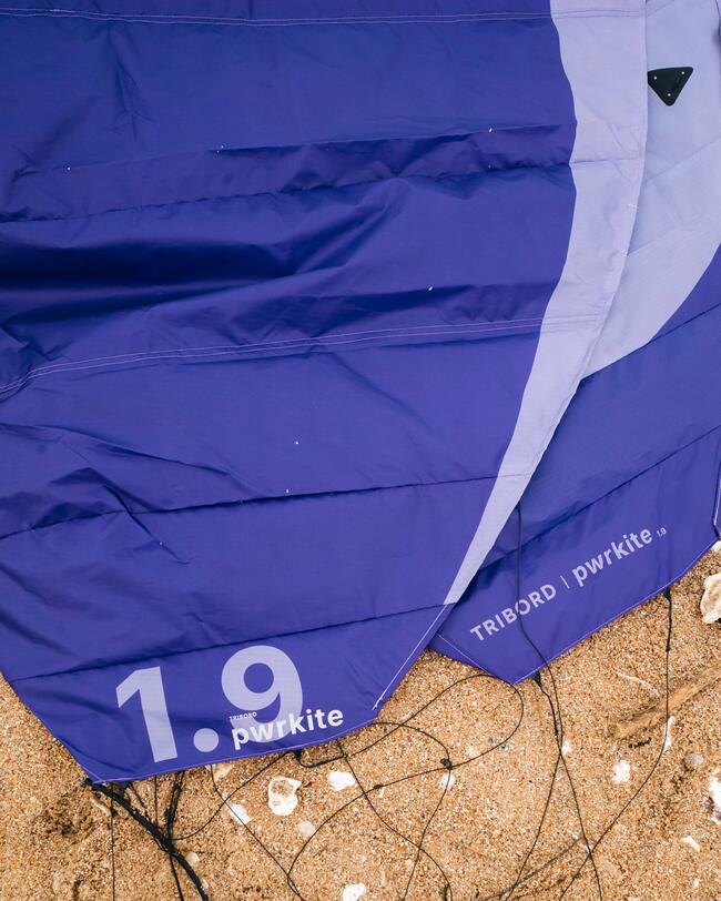 zoom sur une aile de traction violette posée sur le sable