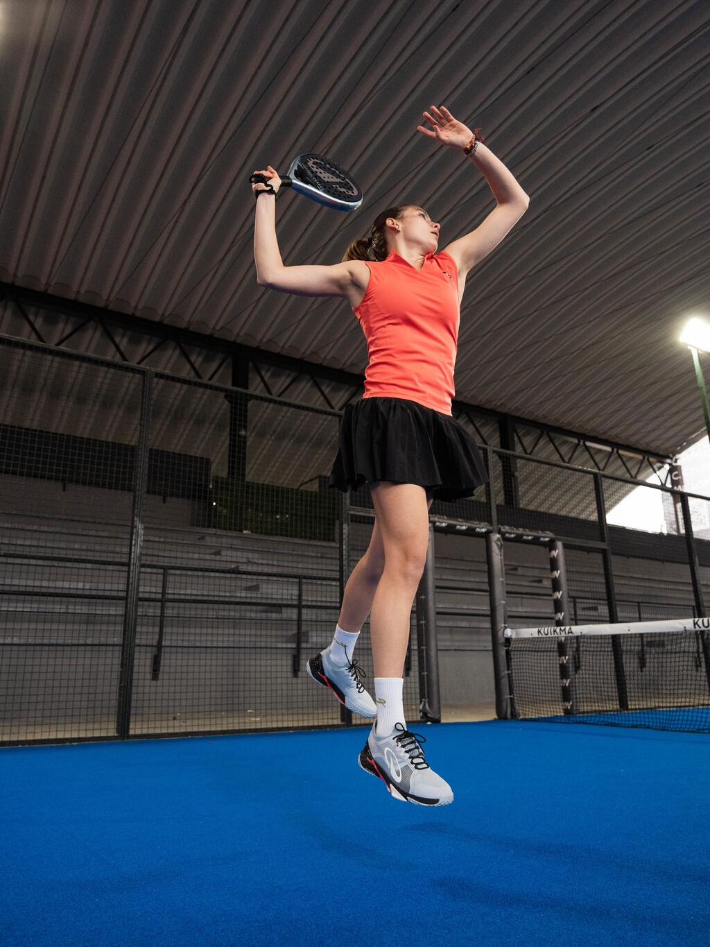 Eien Frau springt hoch beim Padel spielen