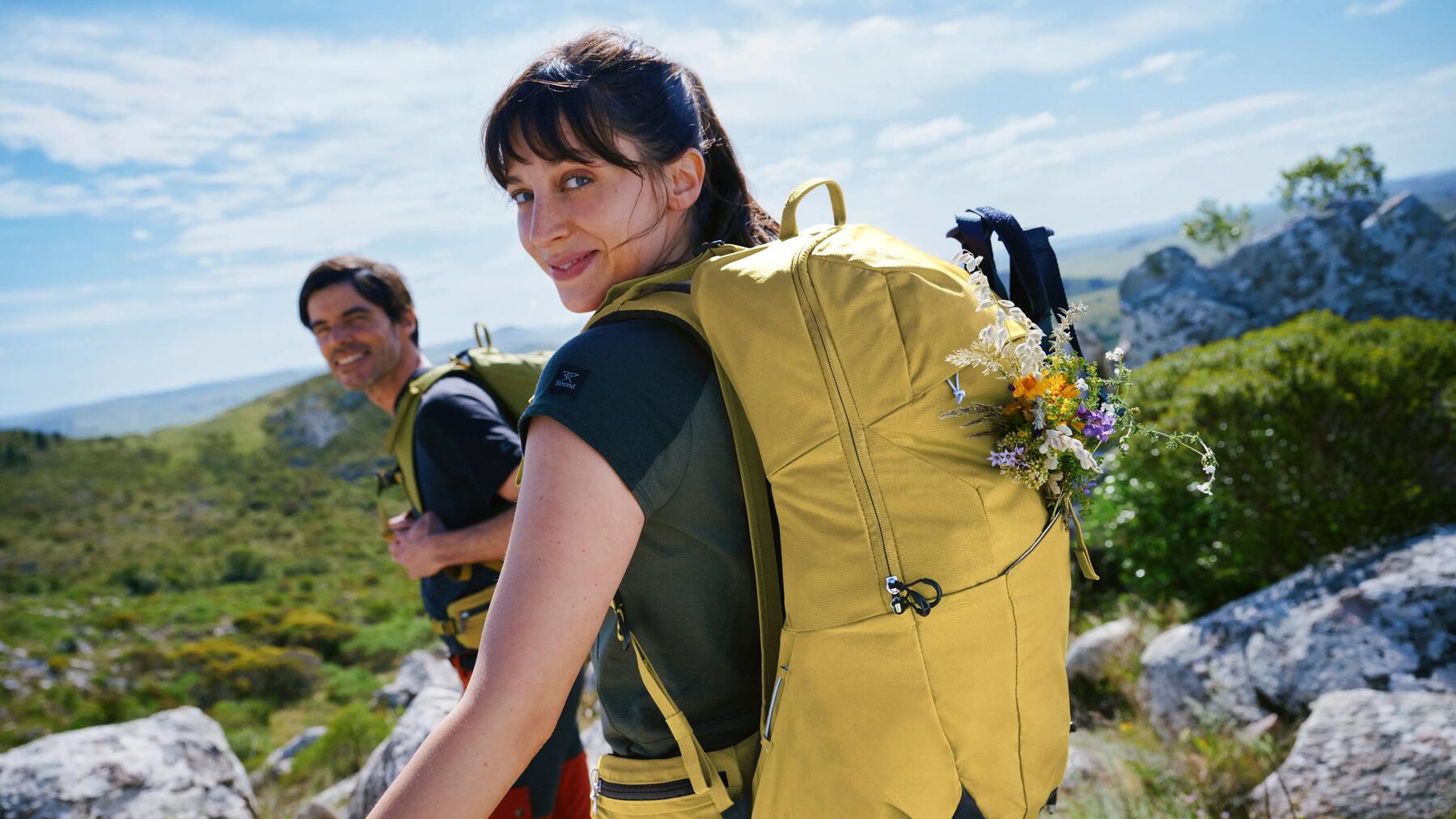 Eine Frau hat Blumen an ihrem Rucksack