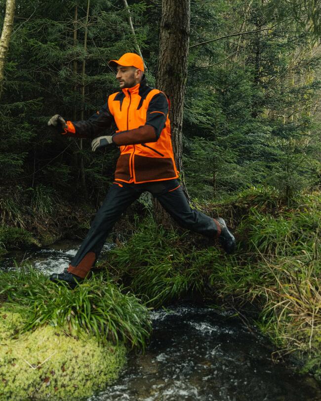 chasseur qui porte le pantalon Supertrack 1200 et qui saute un petit ruisseau