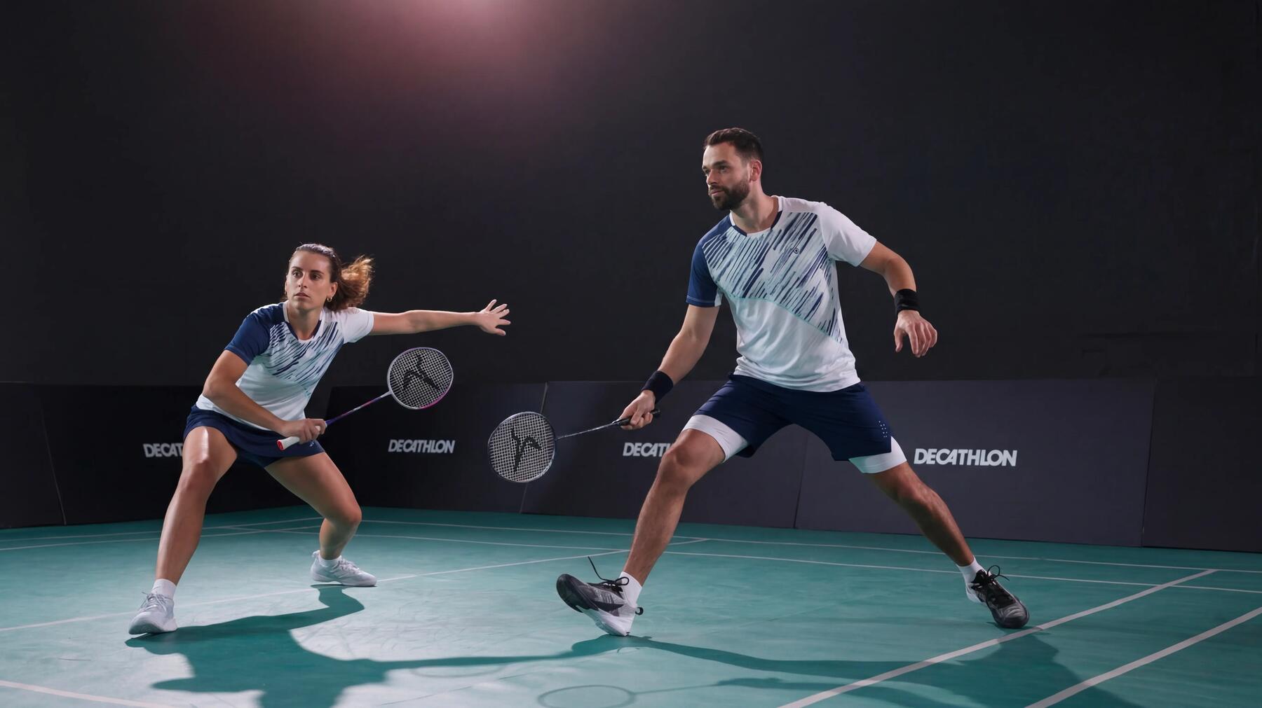 Ein Mann und eine Frau spielen Badminton in der Halle mit Griffbändern