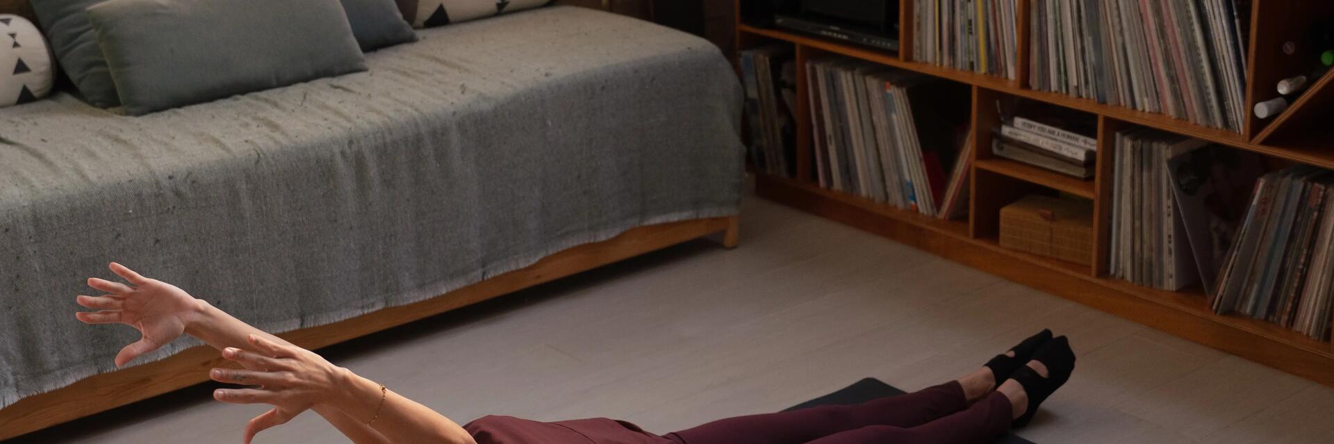 Kobieta siedząca na podłodze z nogami do góry ćwicząca teaser pilates na brzuch