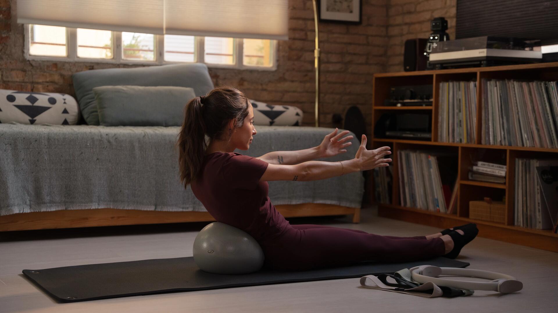 Kobieta w odzieży do pilatesu wykonująca ćwiczenia pilates rozciągające ciało