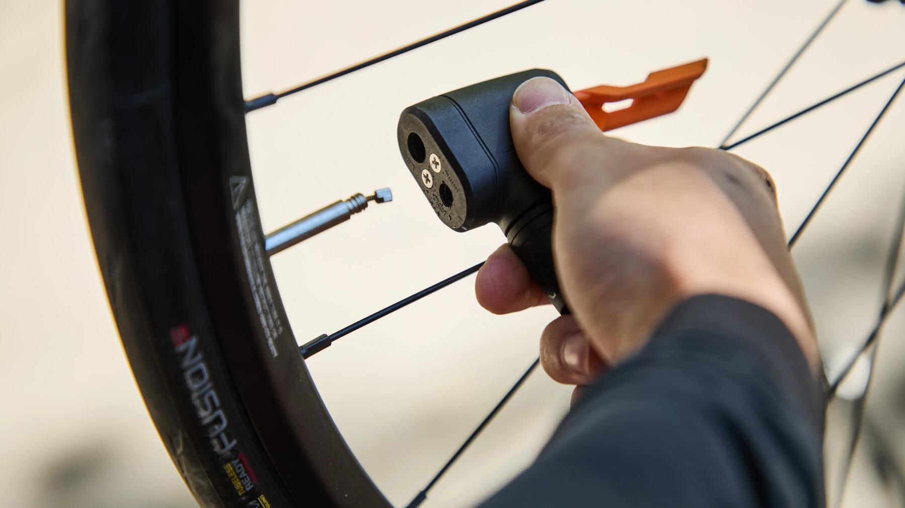 Eine Person setzt eine Fahrradpumpe auf ein Ventil