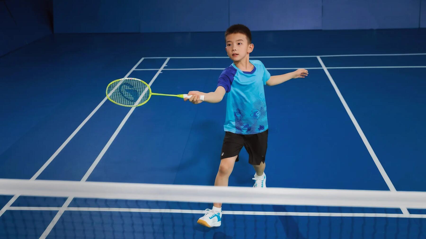 Ein Kind spielt in der Halle mit dem richtigen Badminton-Griffband