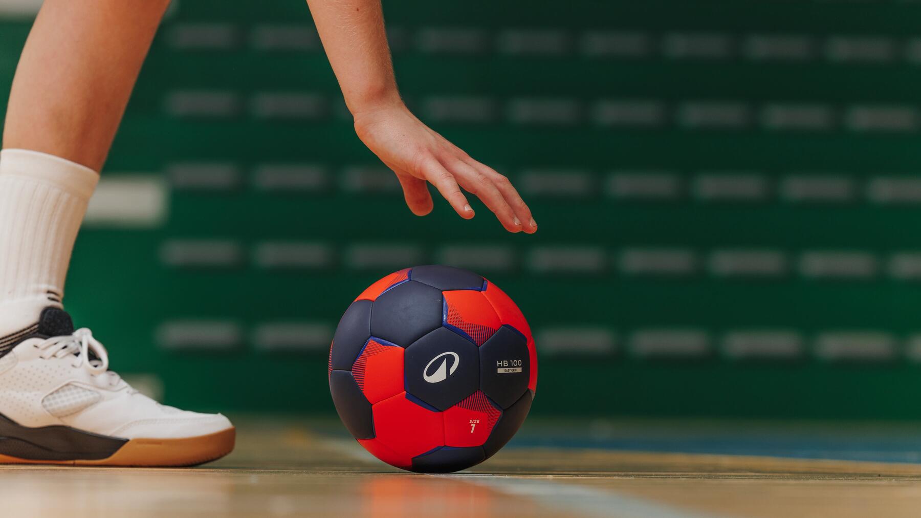 Eine Person greift nach einem Handball