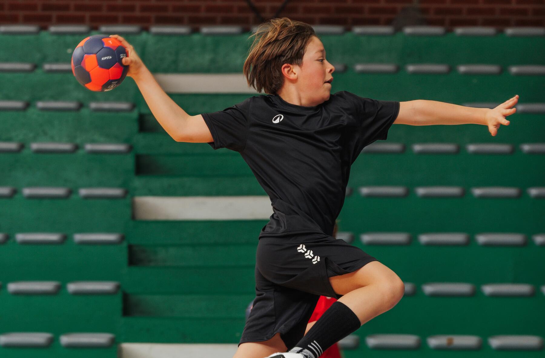 Ein Junge macht einen Torwurf mit einem Handball