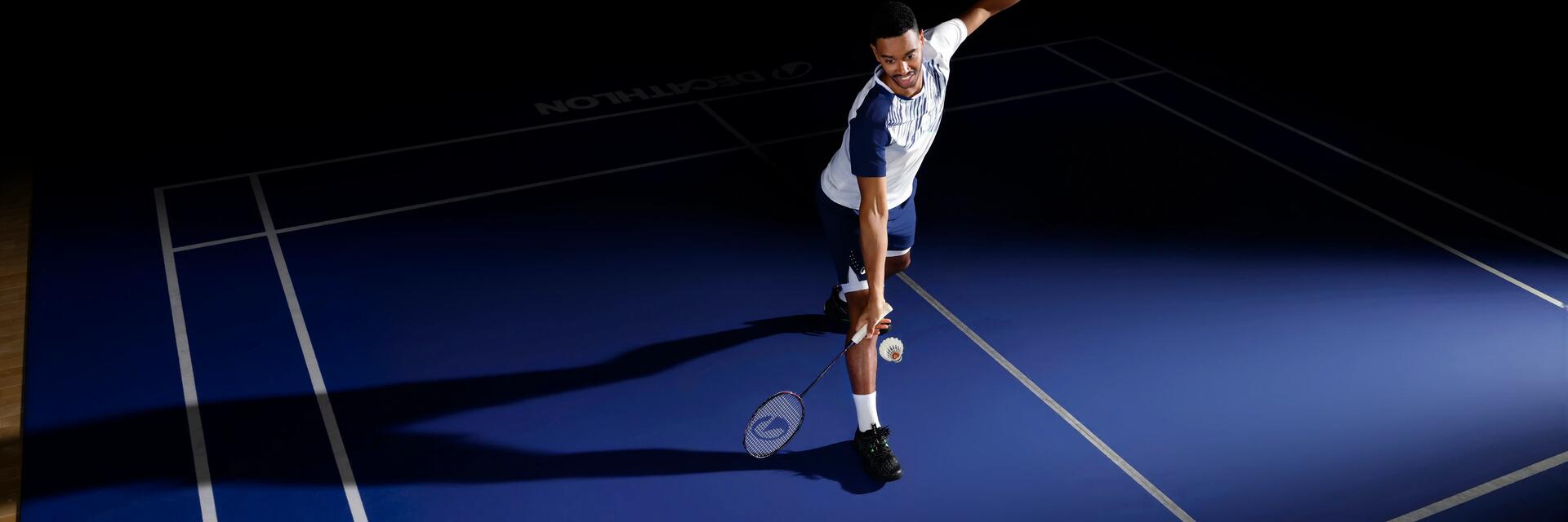 Ein Mann spielt mit dem richtigen Badminton-Griffband in einer dunklen Halle