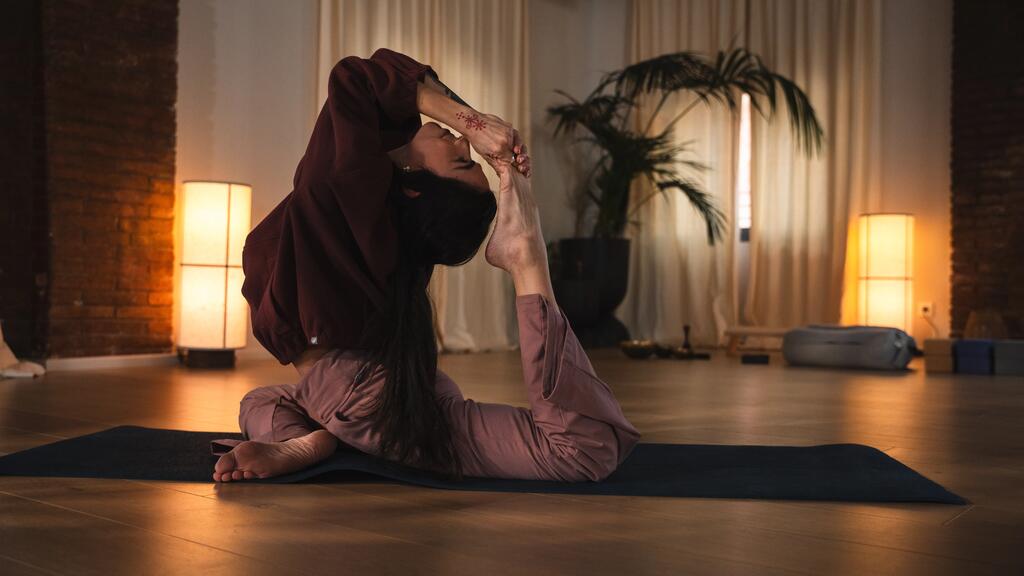 Frau macht eine Yoga-Pose auf der Matte und lächelt